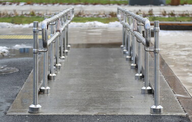 Obraz premium Gentle descent with metal handrails for people with disabilities