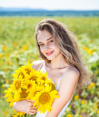 Young beautiful brunette girl with a bouquet of sunflowers