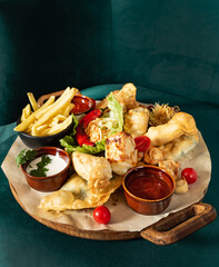 Fried chicken wings rings, fried onion rings on wooden tray