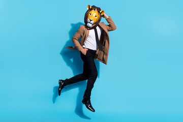 Full size photo of authentic guy lion mask jump up crazy freak occasion isolated over blue color...