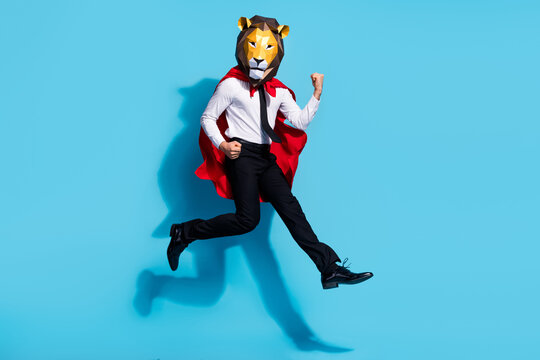 Full body photo of weird guy lion mask jump raise fists up rejoice goal isolated over blue color background