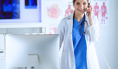 Portrait of a beautiful smiling nurse talking on the phone - 471073751