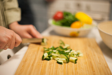 woman cutting cucumbers preparing a salad 