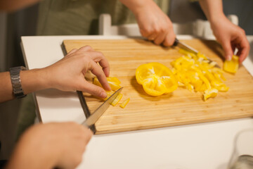 woman cutting yellow bell pepper preparing a salad 