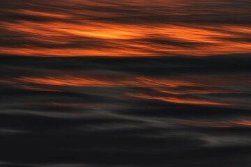 in the atlantic ocean, various hues of colours shape the surface at the never ending sunset around Iceland during summer months