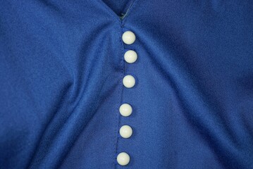 blue fabric texture of crumpled clothes and row white buttons