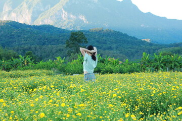 Fototapeta premium the woman enjoyed beautiful view and sweet lovely flowers at the field.