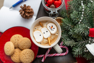 christmas, winter holidays and leisure concept - close up of marshmallow snowman in cup of coffee