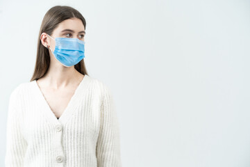 The girl in a mask looks aside. The girl with long dark hair.