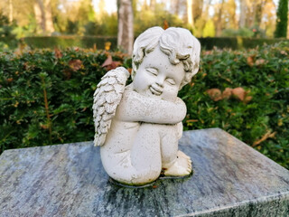 little old angel on a tombstone in the cemetery