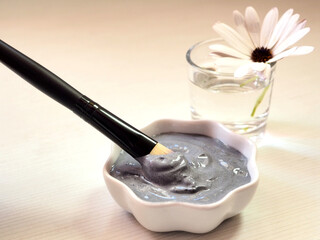 Homemade cosmetic mask for cleansing the skin of the face and white flower on a white background