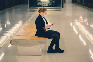 Nice pretty worried young girl wearing mask and headphones in a bus, train or metro going to school
