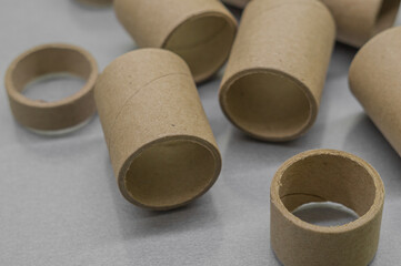 Cardboard spools for winding. Reels made of cardboard. Background of cardboard bobbins. Selective focus