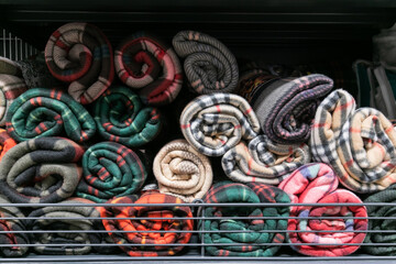 Rolled fleece blankets for sale on a shelf in a supermarket