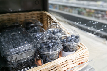 Fresh large blueberries in plastic containers on the store shelf