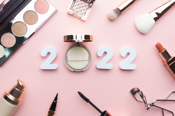 2022 Beauty cosmetic makeup products trends concept. Top view of 2022 white number with powder,...