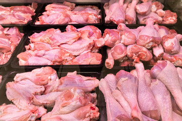 Refrigerated display case with pieces of fresh raw red meat at the butcher in supermarket