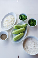 Baby zucchini on a white plate background. over white wooden table.  Organic food.