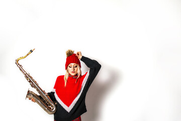 Naklejka premium Beautiful young woman in red sweater holding saxophone, isolated on white background, with copyspace; a Christmas poster