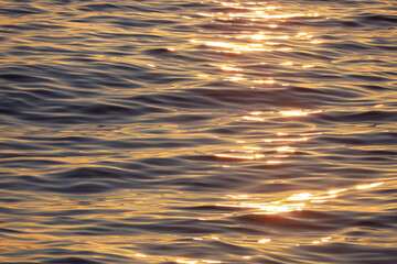 Water surface with small waves. Soft lines, sun glare at dawn. Blue, purple, orange. Abstract...