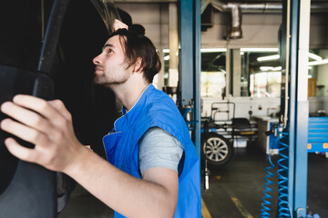 MOT. Vehicle inspection. Closeup caucasian handsome car auto technician mechanic fixing repairing car automobile before test drive.