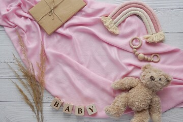 Pregnancy announcement background, expecting a baby girl concept, flat lay composition on pink blanket with boho rainbow decoration and soft toy bear. - Powered by Adobe