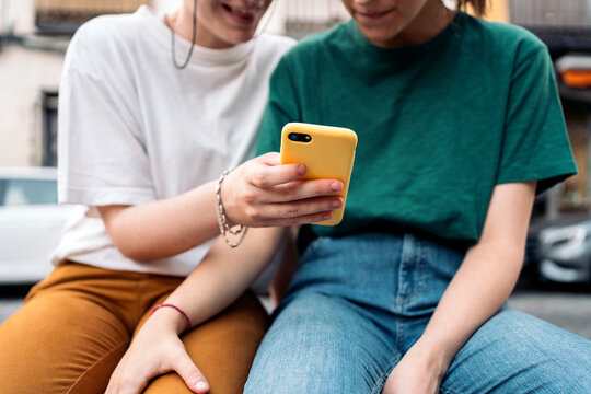 Unrecognizable lesbian couple using smartphone