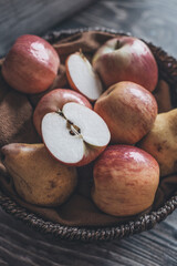 Obraz premium still life apples in a wicker basket on a wooden table