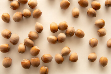 Shelled hazelnuts on beige paper. Food background, top view
