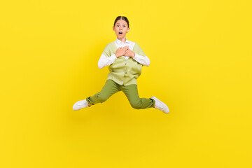 Fototapeta na wymiar Full length body size view of attractive funny impressed girl jumping touching heart isolated on bright yellow color background