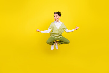 Full length body size view of attractive funny cheerful girl jumping meditating good mood isolated on bright yellow color background