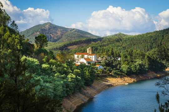 Picturesque village of Dornes in the Zezere river - Portugal. Old church and castle over the river with mountain background