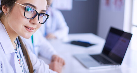 Serious medical team using a laptop in a bright office