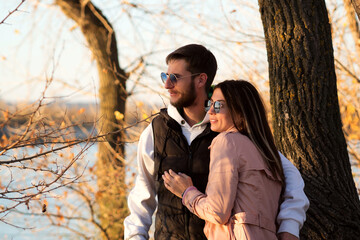 Outdoor shot young loving couple walking. Lovers posing in autumn leaves forest background. Concept of youth, love and lifestyle. Authentic real people portrait. Candid portrait.