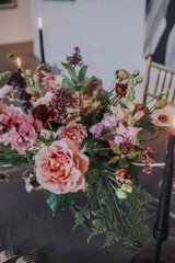 Wedding bouquet of flowers in a vase on a reception table for bride and groom 