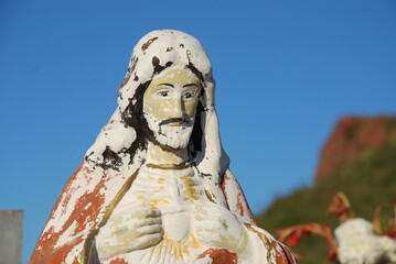 Figura de yeso con forma de cristo deteriorada por el tiempo 