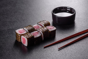 Traditional delicious fresh sushi roll set on a black background