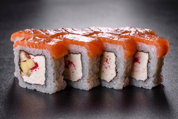 Traditional delicious fresh sushi roll set on a black background