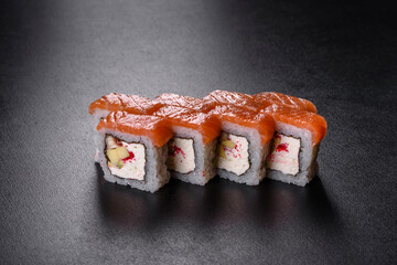 Traditional delicious fresh sushi roll set on a black background
