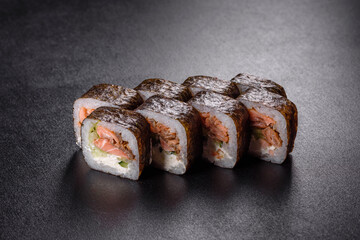 Traditional delicious fresh sushi roll set on a black background
