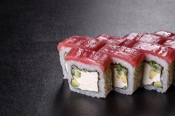 Traditional delicious fresh sushi roll set on a black background