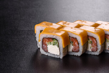 Traditional delicious fresh sushi roll set on a black background