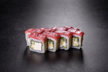 Traditional delicious fresh sushi roll set on a black background
