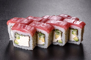 Traditional delicious fresh sushi roll set on a black background