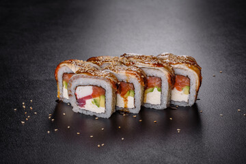 Traditional delicious fresh sushi roll set on a black background