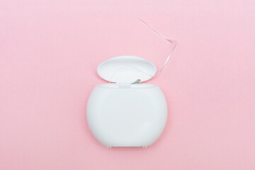 Dental floss on a pink background. Caring for dental health