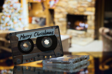 An audio cassette with the inscription Merry Christmas on the background of a burning fire in the...