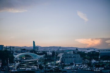 City view with modern buildings and park in Georgia. Modern art park on the sunset. New architecture in Europe. Spectacular sunset in Tbilisi. 
