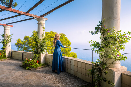 A young blonde girl walking in the patio of an historic villa in Capri island. Capri, Italy.