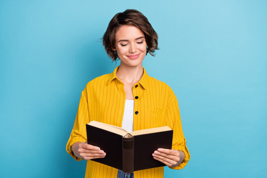 Photo of positive cheerful lady read open textbook learn lesson wear yellow shirt isolated blue color background
